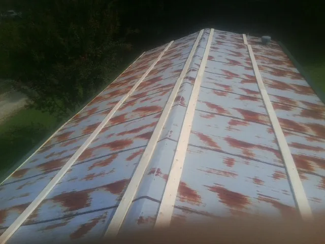 Rusted metal roof panels with new wood purlins before replacement — Storm Damage Roof Repair in Saint Maries by Roofing Brothers