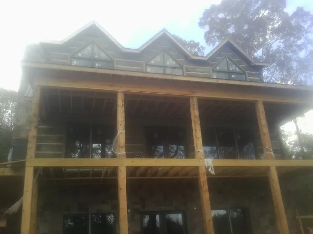 Dormers and porch framing on a large log home under construction in Saint Maries