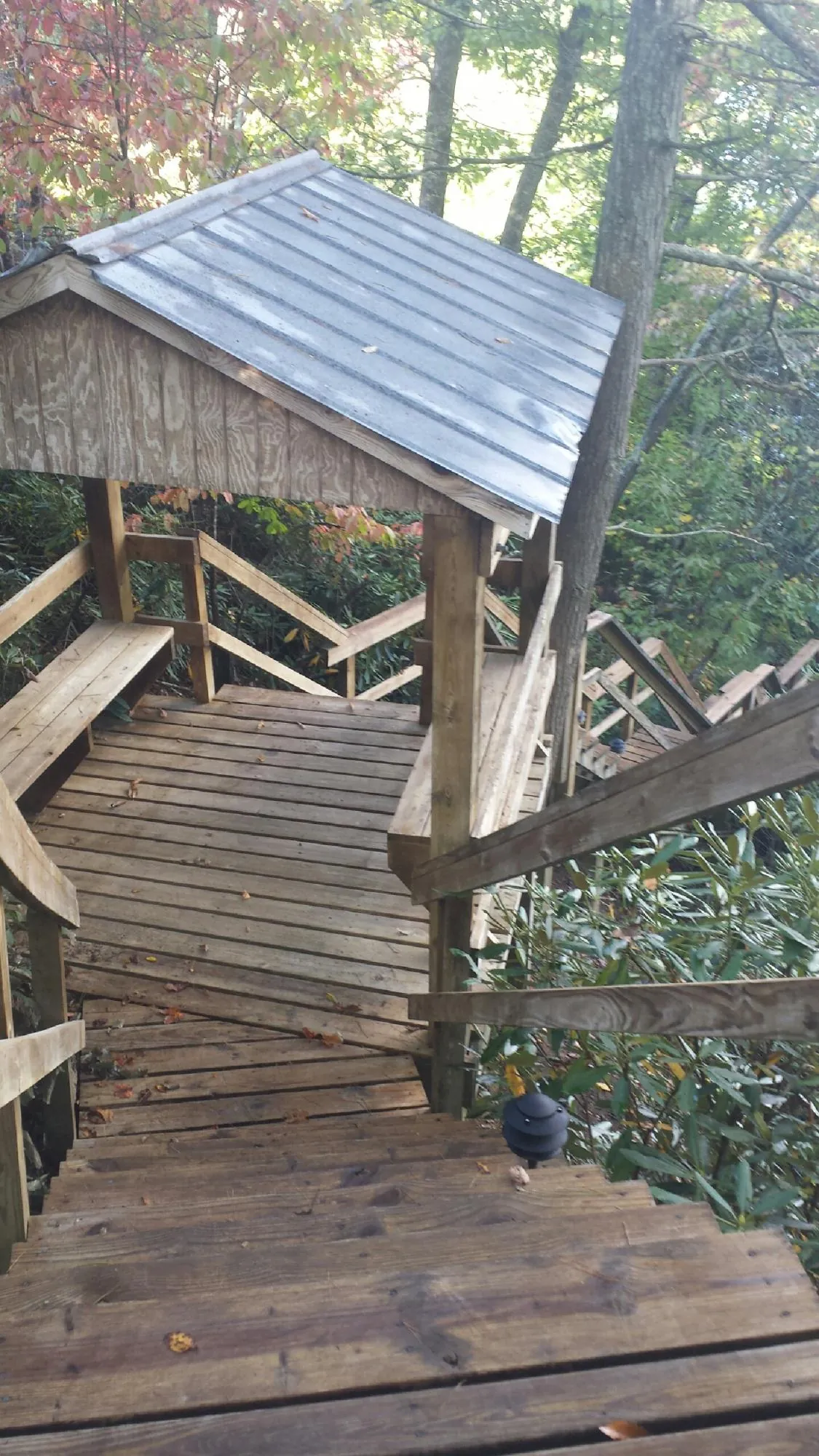 Metal roofed shelter over wooden steps on a wooded walkway — Skylight Repair & Installation work by our crew in Saint Maries